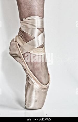 Beine einer Ballerina mit einer schwarzen high Heel Schuh in einem Fuß und eine Pointe Ballet Schuh in der anderen. Stockfoto