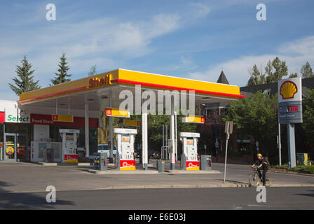 Radfahrer fahren vorbei an Shell Tankstelle Stockfoto