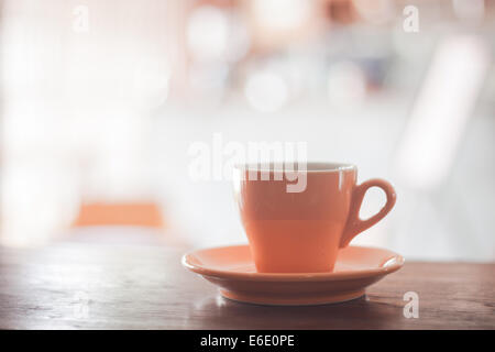 Orange Kaffeetasse auf Holztisch, Fotoarchiv Stockfoto