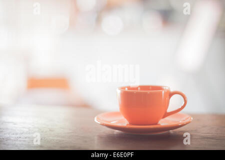 Mini orange Kaffeetasse auf Holztisch, Fotoarchiv Stockfoto