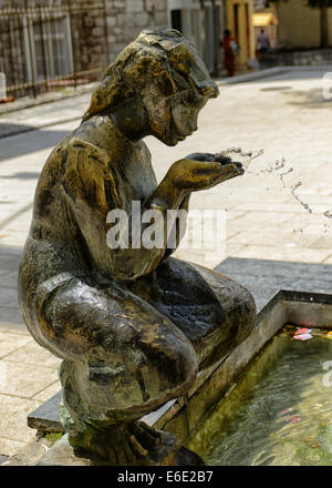 Statue von ein Mädchen trinken Wasser aus der Quelle in Sinj Town Centre, Kroatien Stockfoto