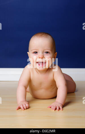 9 Monate altes Baby seinen Kopf hochhalten und Smilling, zeigen seine beiden unteren Schneidezähne. Stockfoto