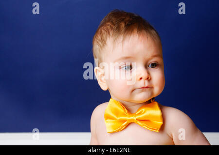 9 Monate altes Baby junge in einer gelben Fliege Stockfoto