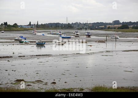 Der Fluss Stour Mündung, Essex, UK, bei Ebbe zeigt Watten und festgemachten Jachten. Eisenbahnbrücke in Ferne. Stockfoto