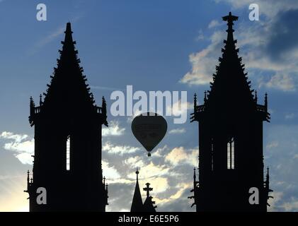 Magdeburg, Deutschland. 21. August 2014. Heißluftballons fliegen Sie über die beiden Türme der Kathedrale Sankt Mauritius und Sankt Katharina in Magdeburg, Deutschland, 21. August 2014. Die Kathedrale ist Sitz eines Bischofs und eines der ältesten gotischen Bauwerke in Deutschland. Foto: JENS WOLF/Dpa/Alamy Live News Stockfoto