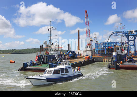 Ein Patrouillenboot verlässt ein Offshore-marine Kabelverlegung Lastkahn im Solent, UK. Stockfoto