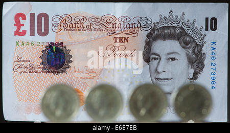 £1 britische Stirling Münzen sind vor einem £10 britische Stirling-Note abgebildet. Stockfoto