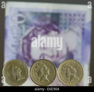 £1 britische Stirling Münzen sind vor einem £20 britische Stirling-Note abgebildet. Stockfoto