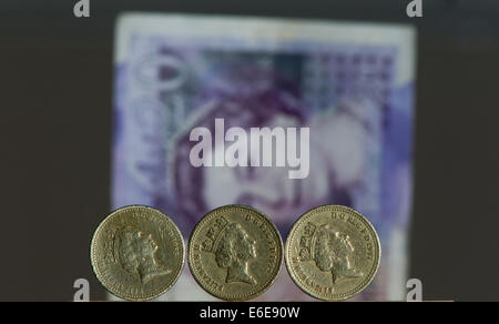 £1 britische Stirling Münzen sind vor einem £20 britische Stirling-Note abgebildet. Stockfoto