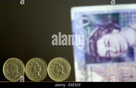 £1 britische Stirling Münzen sind vor einem £20 britische Stirling-Note abgebildet. Stockfoto