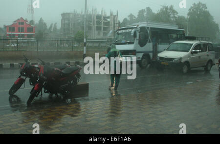 Srinagar, indisch verwalteten Teil Kaschmirs: 22. August 2014: ein Kaschmir-Frauen, die versuchen Passagierbus während der kräftige Schauer in der nach Mittag in Srinagar zu stoppen (Credit: Sofi Suhail/Alamy Live News Stockfoto