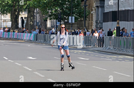 London, England, Vereinigtes Königreich. Junge Frau Rollerskating in Whitehall, während der Verkehr vor ein Radrennen beendet wird Stockfoto