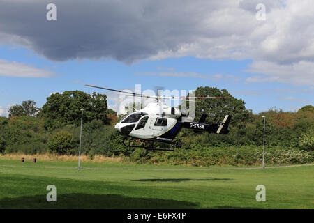 Westen Ewell, Epsom, Surrey, UK. 22. August 2014. Bewohner von West Ewell hatte eine Überraschung heute Nachmittag als KSSA (Kent Surrey Sussex Air Ambulance) landete auf einer Fläche von den Hogsmill Freiraum zwischen Riverview Schule und Waters Estate. Er landete um 13.30 Uhr in Reaktion auf "Ein medizinischer Notfall" auf dem Anwesen. Einheimischen versammelt, um zu sehen, der ungewöhnliche Ort eines Hubschraubers so nah an in der Nähe wohnen, und wie es war Ferienzeit im Sommer viele neugierige Kinder waren daran interessiert, das Ereignis beizuwohnen. Bildnachweis: Julia Gavin UK/Alamy Live-Nachrichten Stockfoto