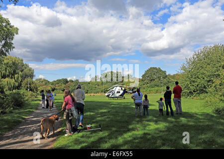 Westen Ewell, Epsom, Surrey, UK. 22. August 2014. Bewohner von West Ewell hatte eine Überraschung heute Nachmittag als KSSA (Kent Surrey Sussex Air Ambulance) landete auf einer Fläche von den Hogsmill Freiraum zwischen Riverview Schule und Waters Estate. Er landete um 13.30 Uhr in Reaktion auf "Ein medizinischer Notfall" auf dem Anwesen. Einheimischen versammelt, um zu sehen, der ungewöhnliche Ort eines Hubschraubers so nah an in der Nähe wohnen, und wie es war Ferienzeit im Sommer viele neugierige Kinder waren daran interessiert, das Ereignis beizuwohnen. Bildnachweis: Julia Gavin UK/Alamy Live-Nachrichten Stockfoto