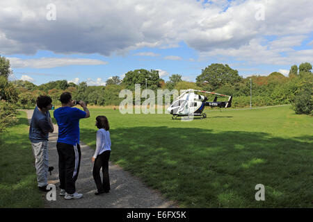 Westen Ewell, Epsom, Surrey, UK. 22. August 2014. Bewohner von West Ewell hatte eine Überraschung heute Nachmittag als KSSA (Kent Surrey Sussex Air Ambulance) landete auf einer Fläche von den Hogsmill Freiraum zwischen Riverview Schule und Waters Estate. Er landete um 13.30 Uhr in Reaktion auf "Ein medizinischer Notfall" auf dem Anwesen. Einheimischen versammelt, um zu sehen, der ungewöhnliche Ort eines Hubschraubers so nah an in der Nähe wohnen, und wie es war Ferienzeit im Sommer viele neugierige Kinder waren daran interessiert, das Ereignis beizuwohnen. Bildnachweis: Julia Gavin UK/Alamy Live-Nachrichten Stockfoto