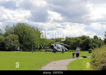 Westen Ewell, Epsom, Surrey, UK. 22. August 2014. Bewohner von West Ewell hatte eine Überraschung heute Nachmittag als KSSA (Kent Surrey Sussex Air Ambulance) landete auf einer Fläche von den Hogsmill Freiraum zwischen Riverview Schule und Waters Estate. Er landete um 13.30 Uhr in Reaktion auf "Ein medizinischer Notfall" auf dem Anwesen. Einheimischen versammelt, um zu sehen, der ungewöhnliche Ort eines Hubschraubers so nah an in der Nähe wohnen, und wie es war Ferienzeit im Sommer viele neugierige Kinder waren daran interessiert, das Ereignis beizuwohnen. Bildnachweis: Julia Gavin UK/Alamy Live-Nachrichten Stockfoto