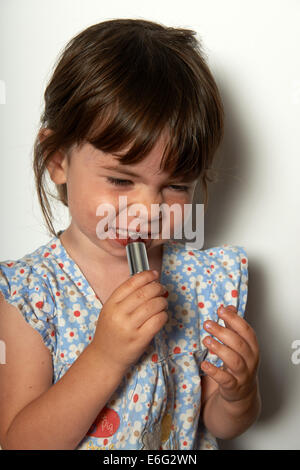 2 - Jahre altes Mädchen spielen mit ihren Mamas Lippenstift Stockfoto