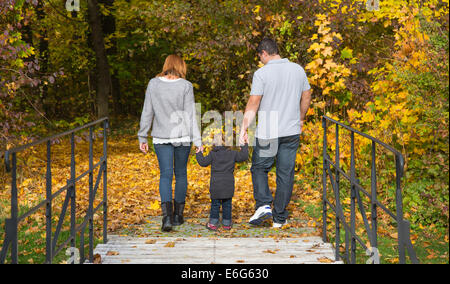 Glückliche junge Familie im Herbst machen eine Wanderung in der Natur. Stockfoto