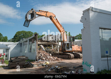 Bagger mit Greifer Abbruch Arbeit auf Bürogebäude in Norwalk, CT.  Materialien für das recycling sortiert. Stockfoto