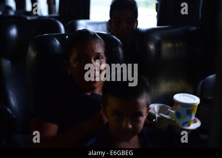 San Pedro Sula, Cortez, Honduras. 28. Juli 2014. Sandra Herrera zusammen mit ihren beiden Söhnen John Terry, 5, im Schoß, und Alex, 17, nach hinten in den Bus zurück nach Hause nach Tegucigalpa nach Alex aus Mexiko auf dem Weg in die USA © Miguel Juarez Lugo abgeschoben wurde/ZUMA Wire/Alamy Live News Stockfoto