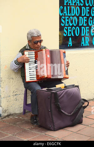 BANOS, ECUADOR - 28. Februar 2014: Unbekannter Mann Akkordeon zu spielen, am Eingang der Markthalle in Ambato Straße Stockfoto