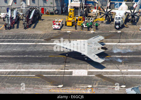 Die US Navy X-47 b autonomen stealth unbemannten eine verhaftete Landung auf dem Flugdeck des Flugzeugträgers USS Theodore Roosevelt während Tests demonstriert die Fähigkeit führt, sicher und nahtlos mit bemannten Luftfahrzeugen 17. August 2014 in den Atlantischen Ozean zu betreiben. Stockfoto