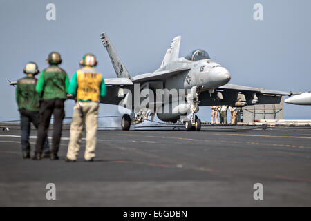 Ein Navy F/A-18F Super Hornet-Kampfflugzeuge landet auf dem Flugdeck des Flugzeugträgers USS George H.W. Bush nach der Rückkehr von einer Mission zur Unterstützung der irakischen militärischen 14. August 2014. Präsident Obama ermächtigt gezielte Luftangriffe auf US-Soldaten von Extremisten bekannt als der islamische Staat im Irak und in der Levante zu schützen. Stockfoto