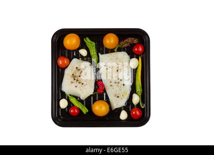 Draufsicht der frischen rohen Cod Fish Fillets Kochen Pfanne mit Tomaten, Knoblauch, Paprika und Pfeffer Salz isoliert auf weiss Stockfoto