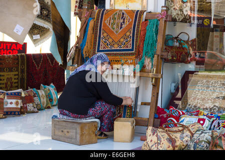 ALANYA, Türkei - 22. Juni 2014: Eine Frau auf der Straße von Alanya Teppich webt. Stockfoto