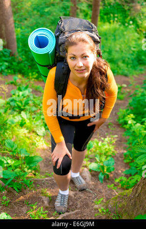 Frau mit einem Rucksack auf dem Hügel im Wald Stockfoto