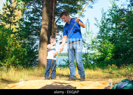 Vater und Sohn setzen ein Zelt auf dem Campingplatz Stockfoto