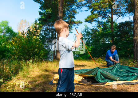 kleinen Sohn hilft, ein Zelt auf die Natur zu etablieren Stockfoto