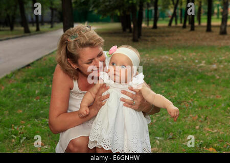 Großmutter im Freien auf der Terrasse mit Baby Lächeln Stockfoto