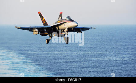 Ein Kampfflugzeug der US Navy F/A - 18C Hornet bereitet, auf dem Flugdeck des Flugzeugträgers USS George H.W. Bush nach einer Mission zur Unterstützung der irakischen militärischen 12. August 2014 zu landen. Präsident Obama ermächtigt gezielte Luftangriffe auf US-Soldaten von Extremisten bekannt als der islamische Staat im Irak und in der Levante zu schützen. Stockfoto