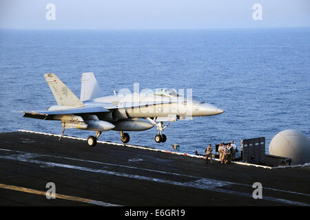 Ein Kampfflugzeug der US Navy F/A - 18C Hornet landet auf dem Flugdeck des Flugzeugträgers USS George H.W. Bush nach einer Mission zur Unterstützung der irakischen militärischen 12. August 2014. Präsident Obama ermächtigt gezielte Luftangriffe auf US-Soldaten von Extremisten bekannt als der islamische Staat im Irak und in der Levante zu schützen. Stockfoto