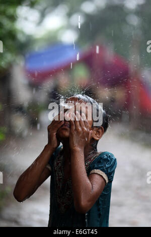 Dhaka, Bangladesch. 23. August 2014. Slum Kinder genießen Regen in Dhaka.Dhaka die zweite am meisten gefährdeten Stadt ist zu schweren Überschwemmungen unter neun Küstenstädte weltweit und bleibt so bis zum Jahr 2100, wenn gegen die Bedrohung durch Maßnahmen eine internationale Studie Credit schlägt: Zakir Hossain Chowdhury/ZUMA Draht/Alamy Live News Stockfoto