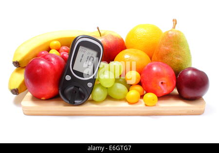 Blutzuckermessgerät und frischen reifen Früchten liegen auf Holzbrett, Konzept für gesunde Ernährung und Diabetes. Isoliert auf weiß ba Stockfoto