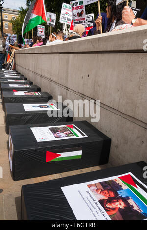 London, UK. 23. August 2014. "Särge" Zeile der Bürgersteig, jeweils mit einem Bildnis von Kindern getötet, da Israel seinen Betrieb in der Brandung gegen die Hamas als Hunderte von Pro-palästinensischen Demonstranten begann zeigen außen Downing Street fordern, dass Großbritannien stoppt Israel Bewaffnung. Bildnachweis: Paul Davey/Alamy Live-Nachrichten Stockfoto