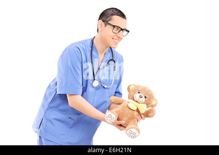 Jungen männlichen Arzt geben einen Teddybär isoliert auf weißem Hintergrund Stockfoto