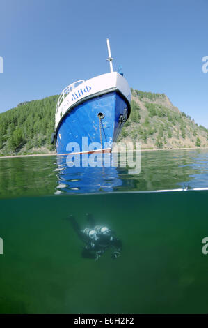 Split Level, schwimmt Taucher unter das Boot, den Baikalsee, Sibirien, Russland, Eurasien Stockfoto