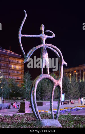 eine Nachtansicht einer Bronzestatue in Pseudo-primitiven Stil mit einem Mitfahrer auf Reiten rückwärts mit einem Bogen schießen Stockfoto