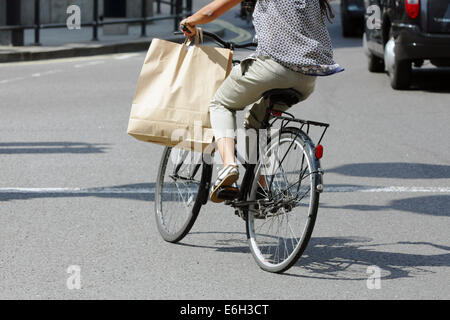 Ein Radfahrer mit dem Fahrrad in London beim Tragen einer Tasche am Lenker Stockfoto