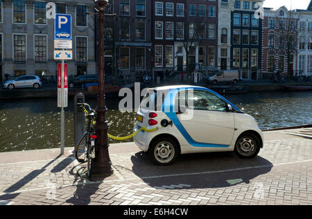 Elektro-Auto neben einem Amsterdamer Kanal eingesteckt Stockfoto