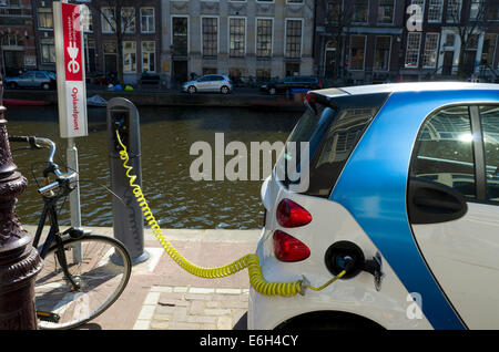 Elektro-Auto neben einem Amsterdamer Kanal eingesteckt Stockfoto