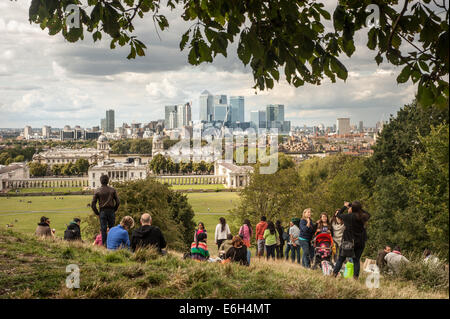 London, UK - 23. August 2014: Besucher genießen den Blick auf die Canary Wharf Wolkenkratzer vom Greenwich Park in London Stockfoto