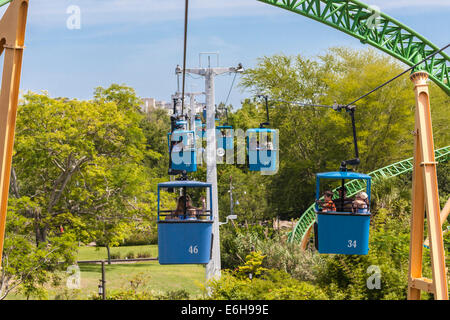 Park Gäste Reiten den Skyride Cable Cars vorbei an der Achterbahn Cheetah Hunt im Busch Gardens Tampa Bay in Tampa, Florida Stockfoto