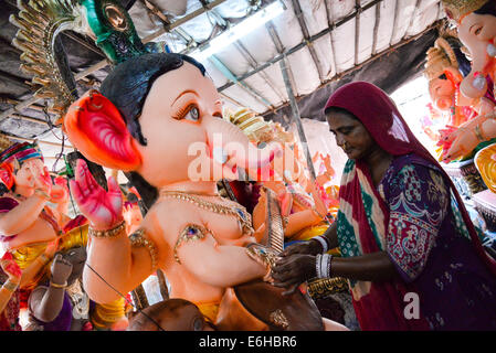 Ahmedabad, Gujarat, Indien, 24. August 2014. : Reinigung der Idol am Sonntagmorgen zu verkaufen, Gulbai Tekra Maniben ist der einzelne größte Lieferant von Ganesha Idole in Ahmedabad, Gujarat in Indien. Bildnachweis: Nisarg Lakhmani/Alamy Live-Nachrichten Stockfoto