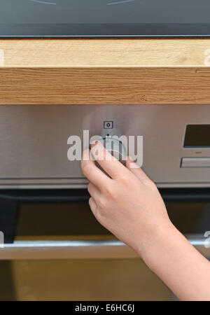 Gefährliche Situation in der Küche. Kind spielt mit Elektro-Backofen. Stockfoto