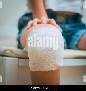 Kind-Knie mit Klebstoff und Gaze-Verband. Stockfoto