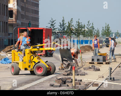Straßenarbeiter mit schwerem Gerät am Viabreda-Projekt gleichzeitig einen Bürgersteig. Breda, Niederlande Stockfoto